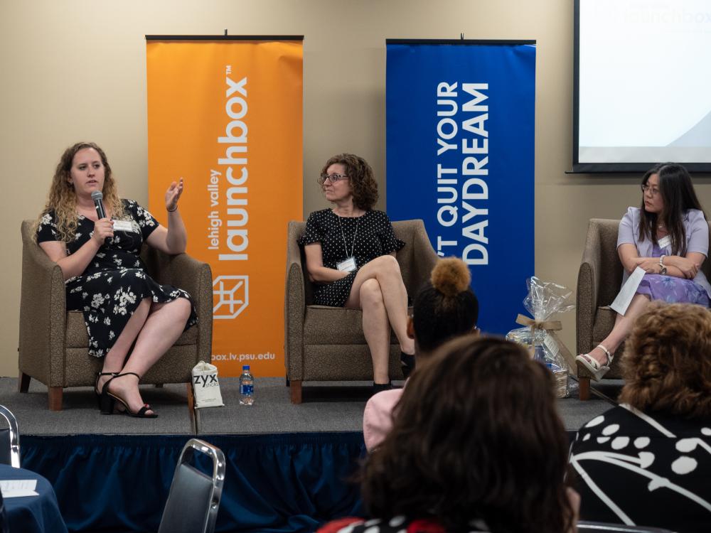 three women panelists seated on a stage