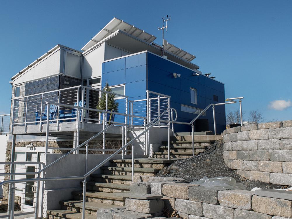 A blue and silver small house pictured on a sunny day.