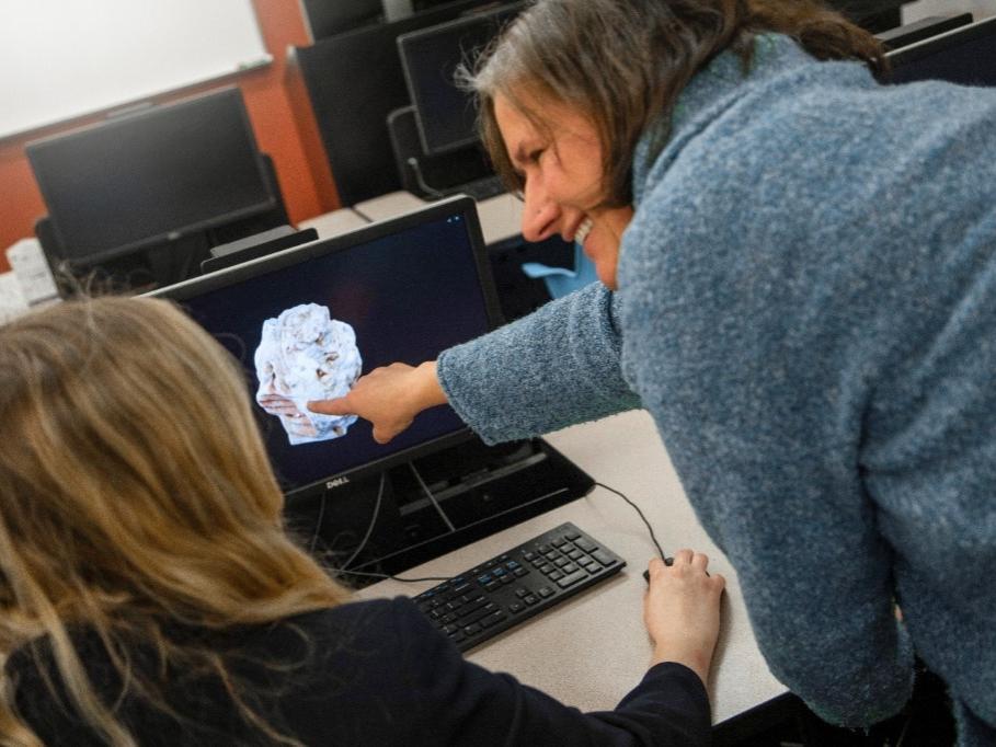 Instructor points at 3D rock on student's computer