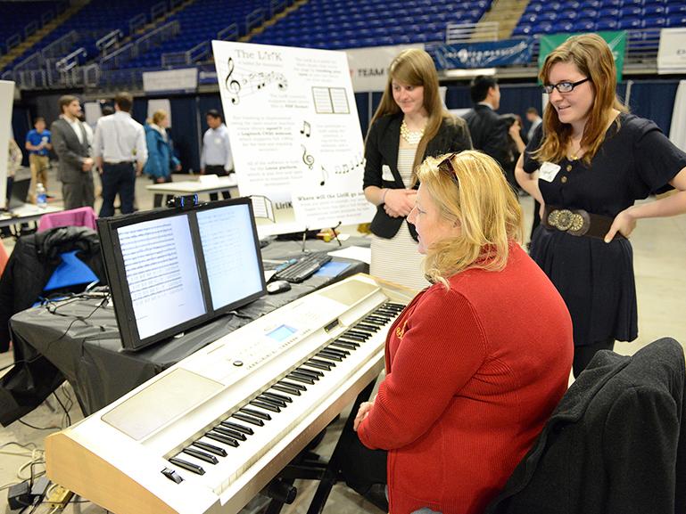 Students demonstrate the "LiriK," a tablet for sheet music that turns the page by tracking a person's eyes.