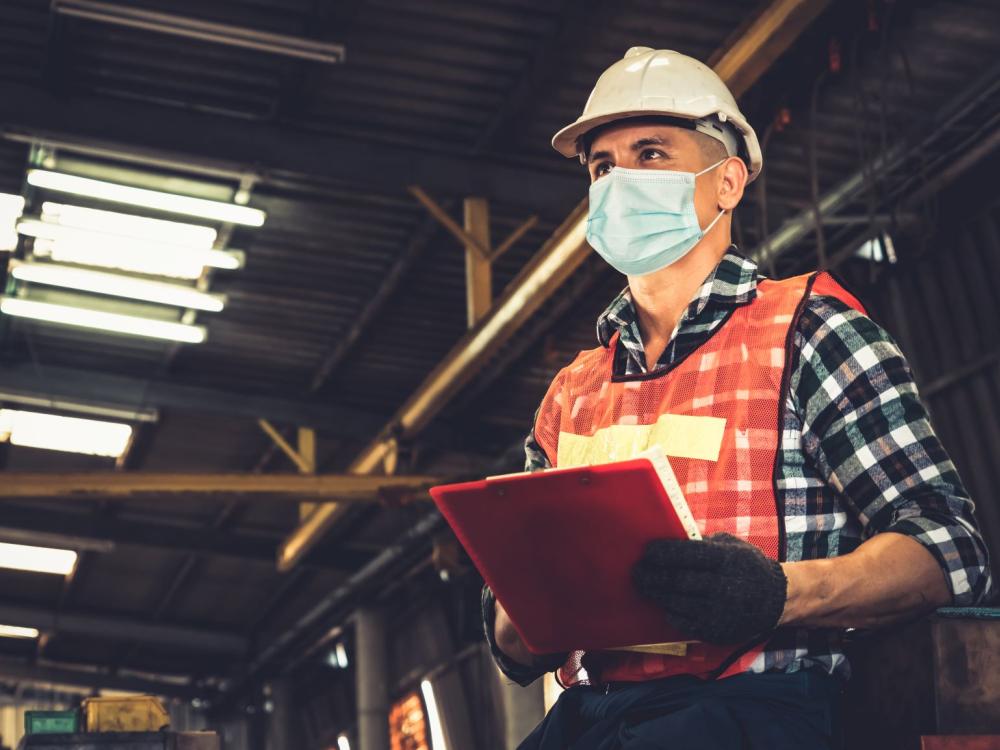 Factory worker with face mask protecting from outbreak of COVID-19.