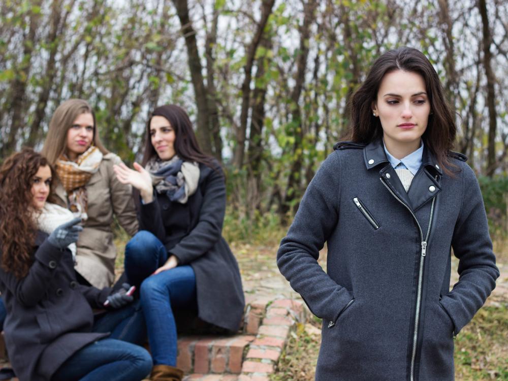 Upset girl with friends gossiping 