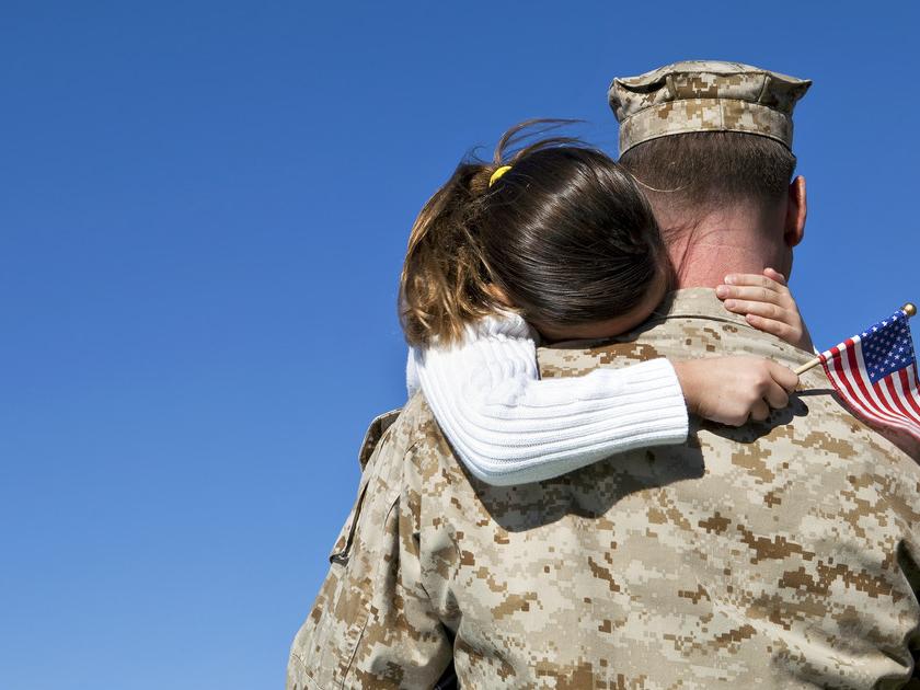 Military man hugs daughter