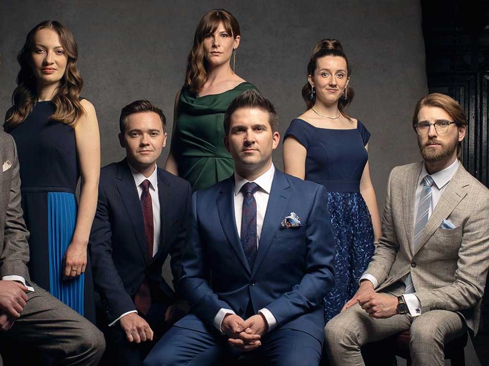 A group of men and women pose for a formal photo.