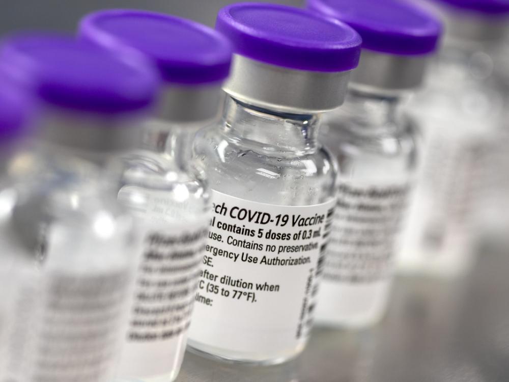 A close-up of several small bottles of COVID-19 vaccine, side by side.