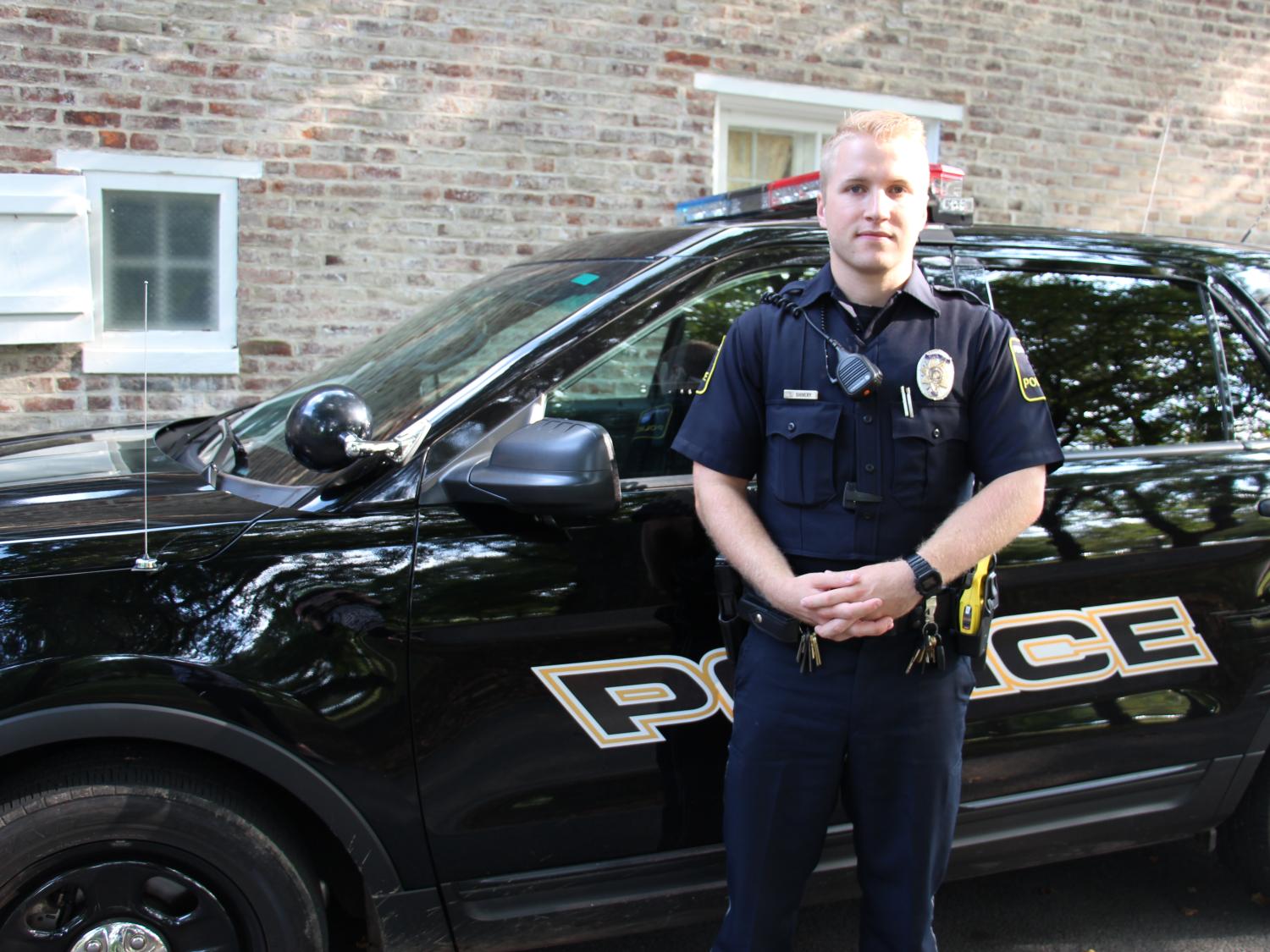 University Police Officer Luke Shivery next to patrol car