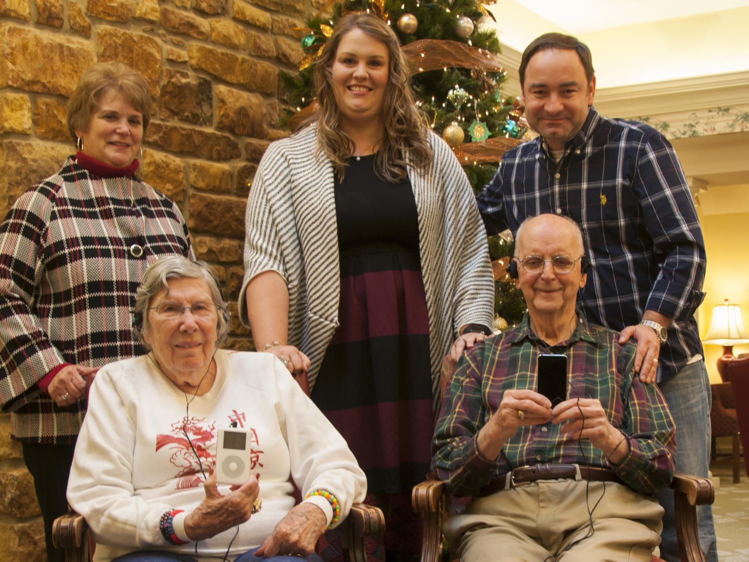 Penn State staff stand around two patients holding iPods