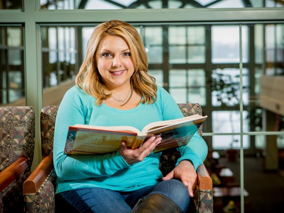 A Penn State Behrend student reads a book in Lilley Library.