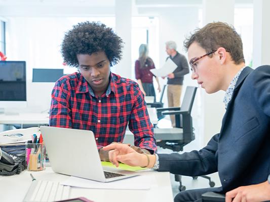 Two men sitting at computer