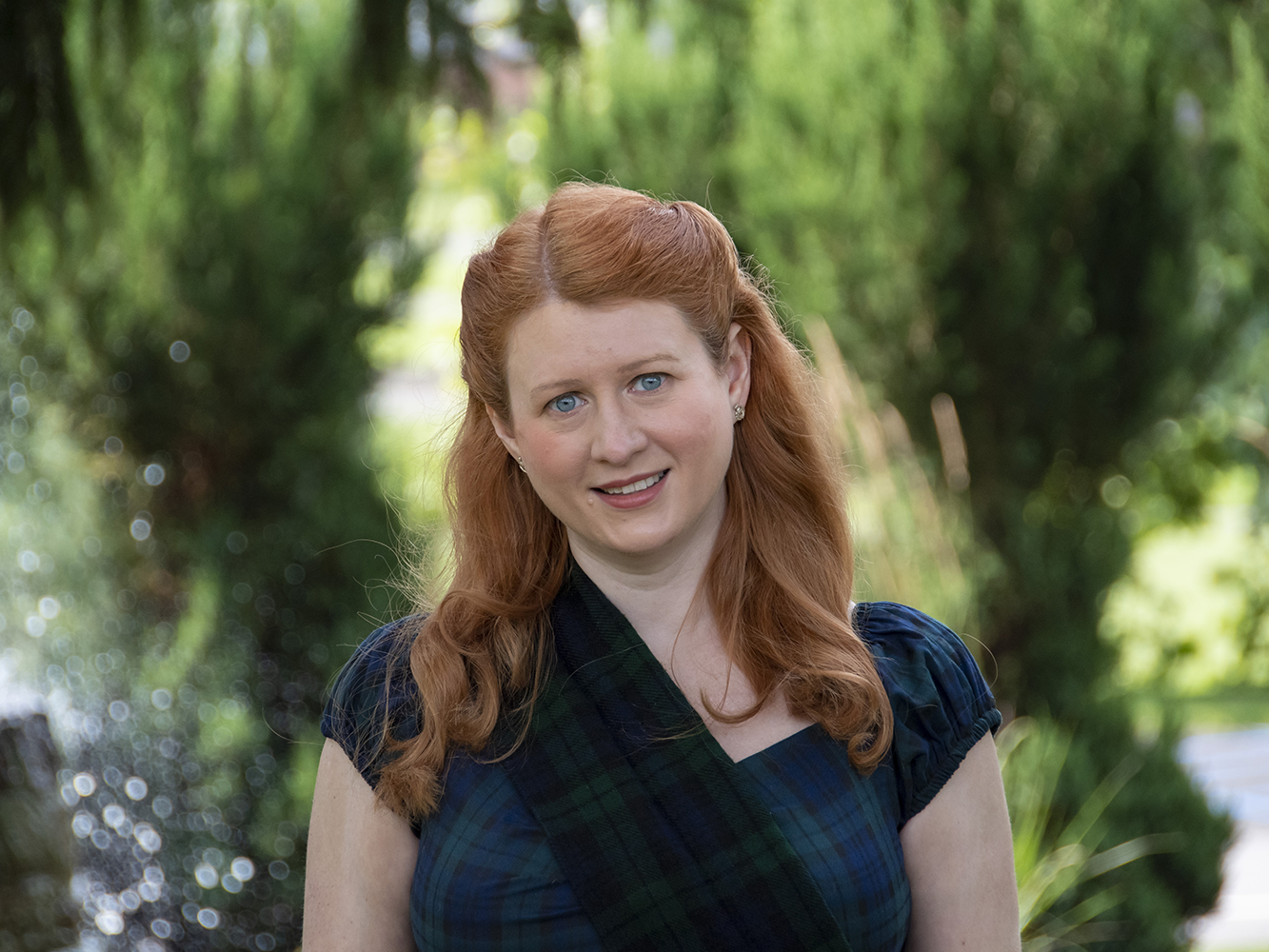 An image of author and professor, Valerie Schrader, against a softly focused campus background.