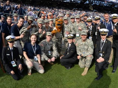 Service personnel at football game with lion mascot