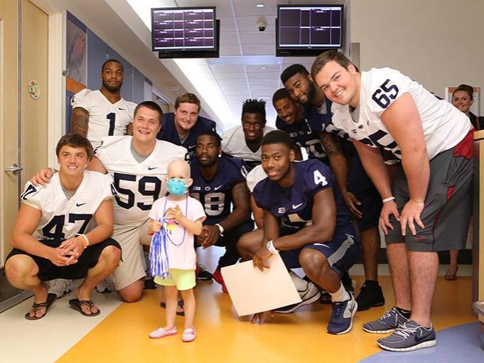 Members of the Penn State football team pose with a child at Penn State Hershey Children's Hospital