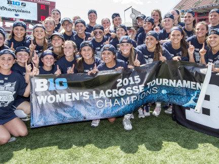 Penn State women's lacrosse team members hold 2015 Big Ten Tournament Champion banner