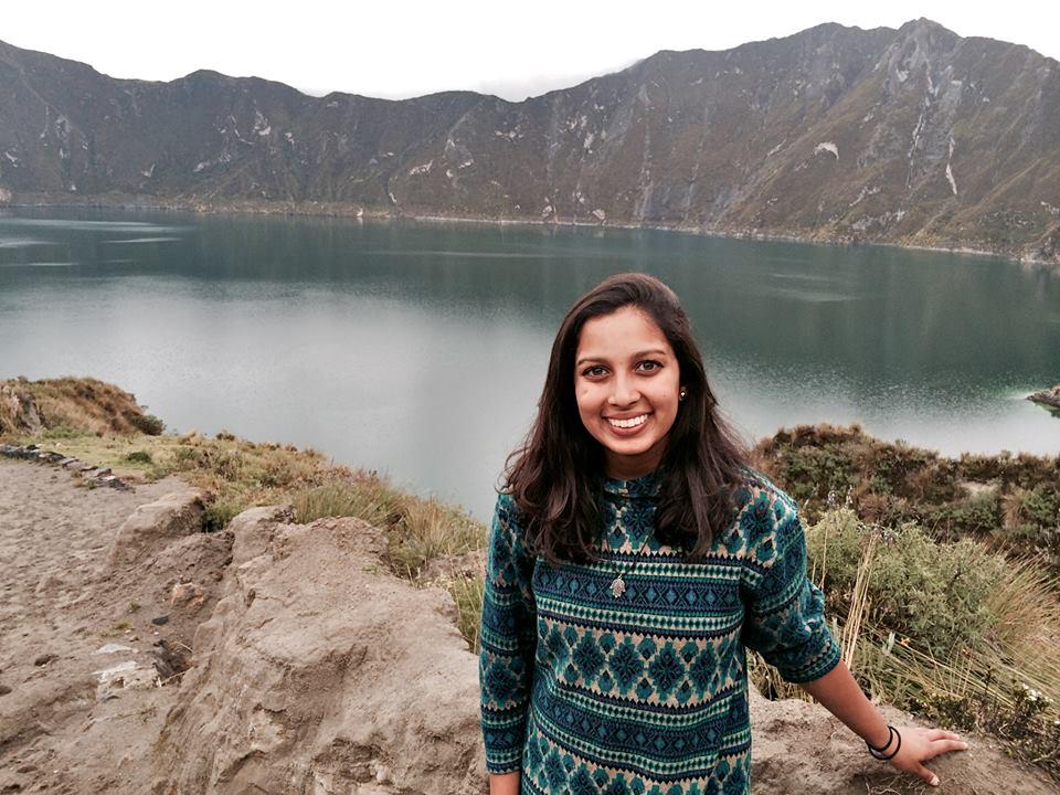 student stands in front of Ecuadorian landscape