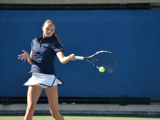 Women's tennis player returning ball