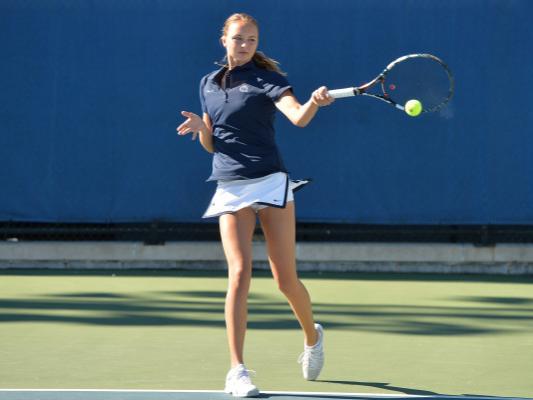 Women's tennis player returning ball