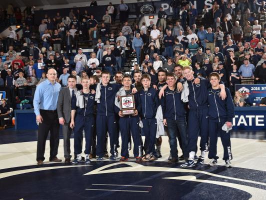 Wrestlers pose with plaque