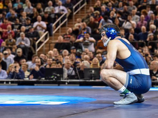 Wrestler crouched on mat