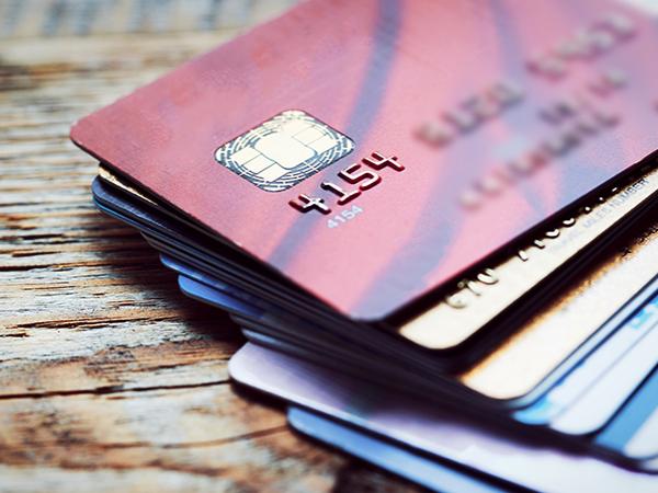 A stack of credit cards on a wooden surface