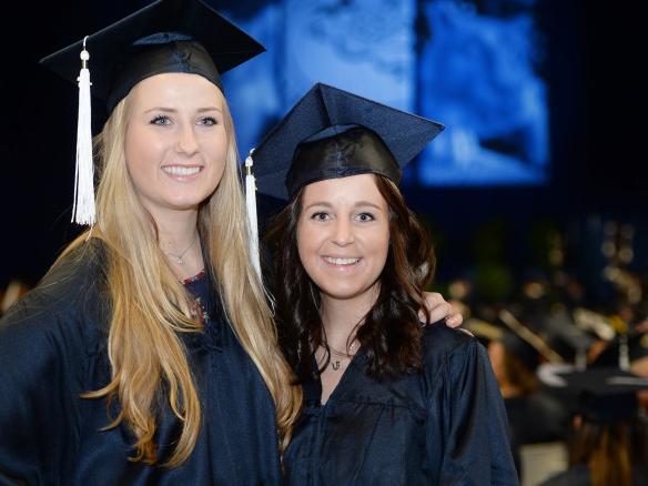 Two female student-athletes at commencement