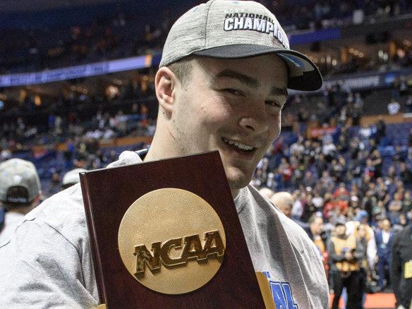 Wrestler hugs NCAA championship trophy
