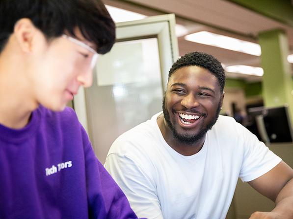 Student smiles as he talks with a Tech Tutor