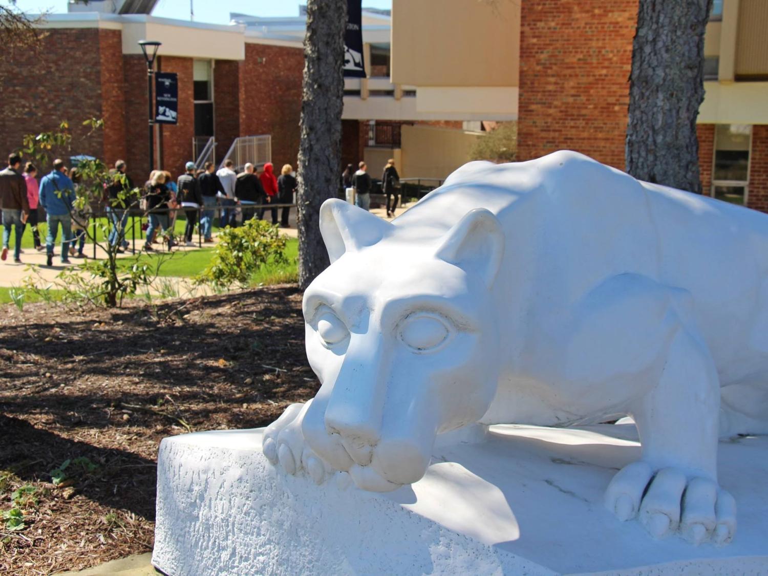 Tour group passes behind lion shrine at Penn State New Kensington
