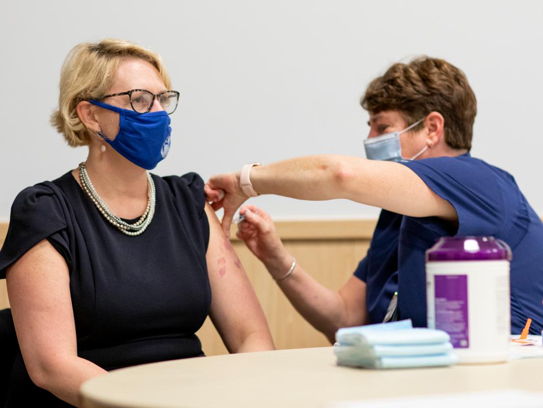 A nurse gives a woman a flu shot