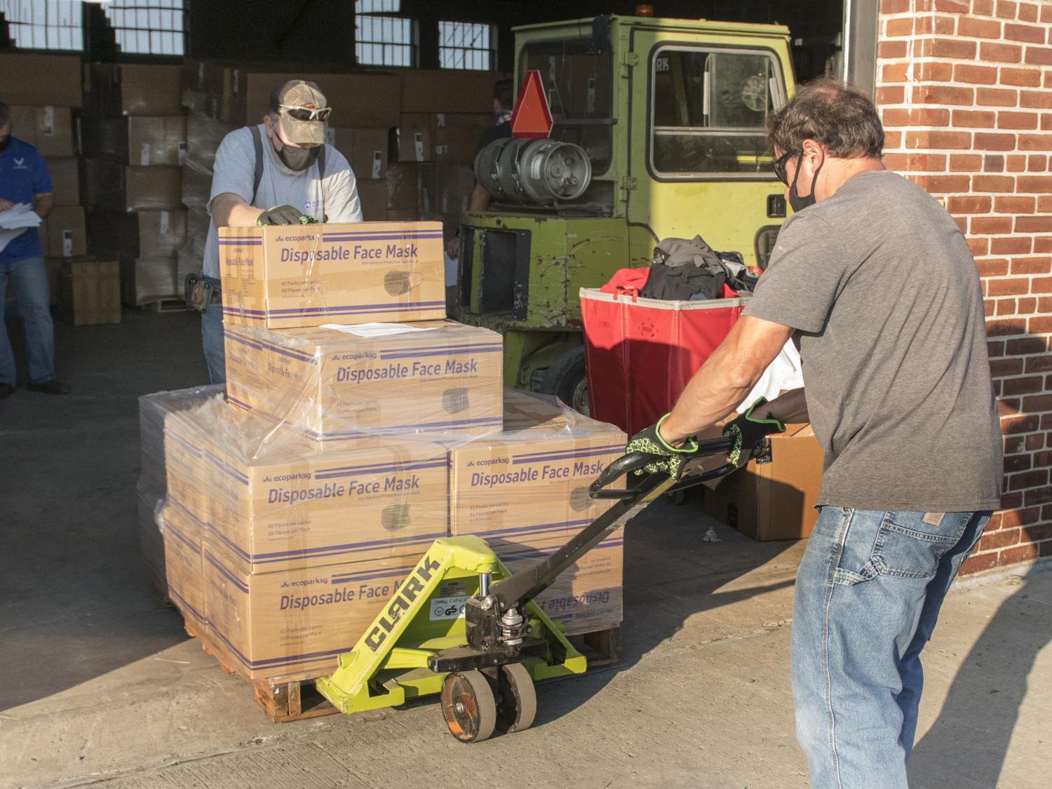 Workers move pallet of procedure masks