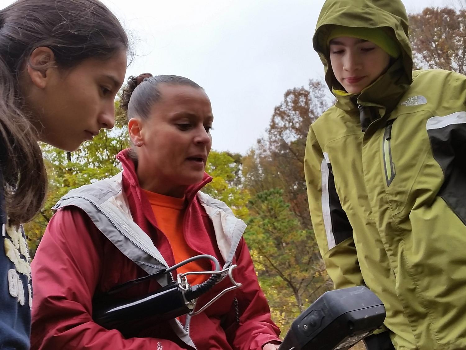 Penn State researcher Jennifer Williams shows State College high school students how to read water quality testing equipment
