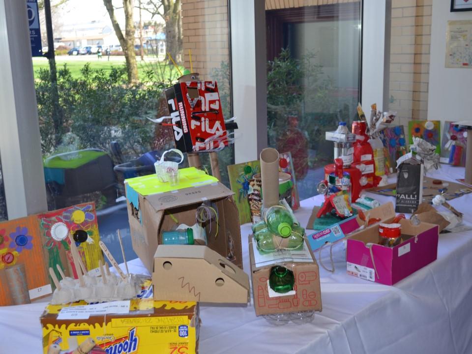 Several upcycled art projects on a table in the campus' Atrium area