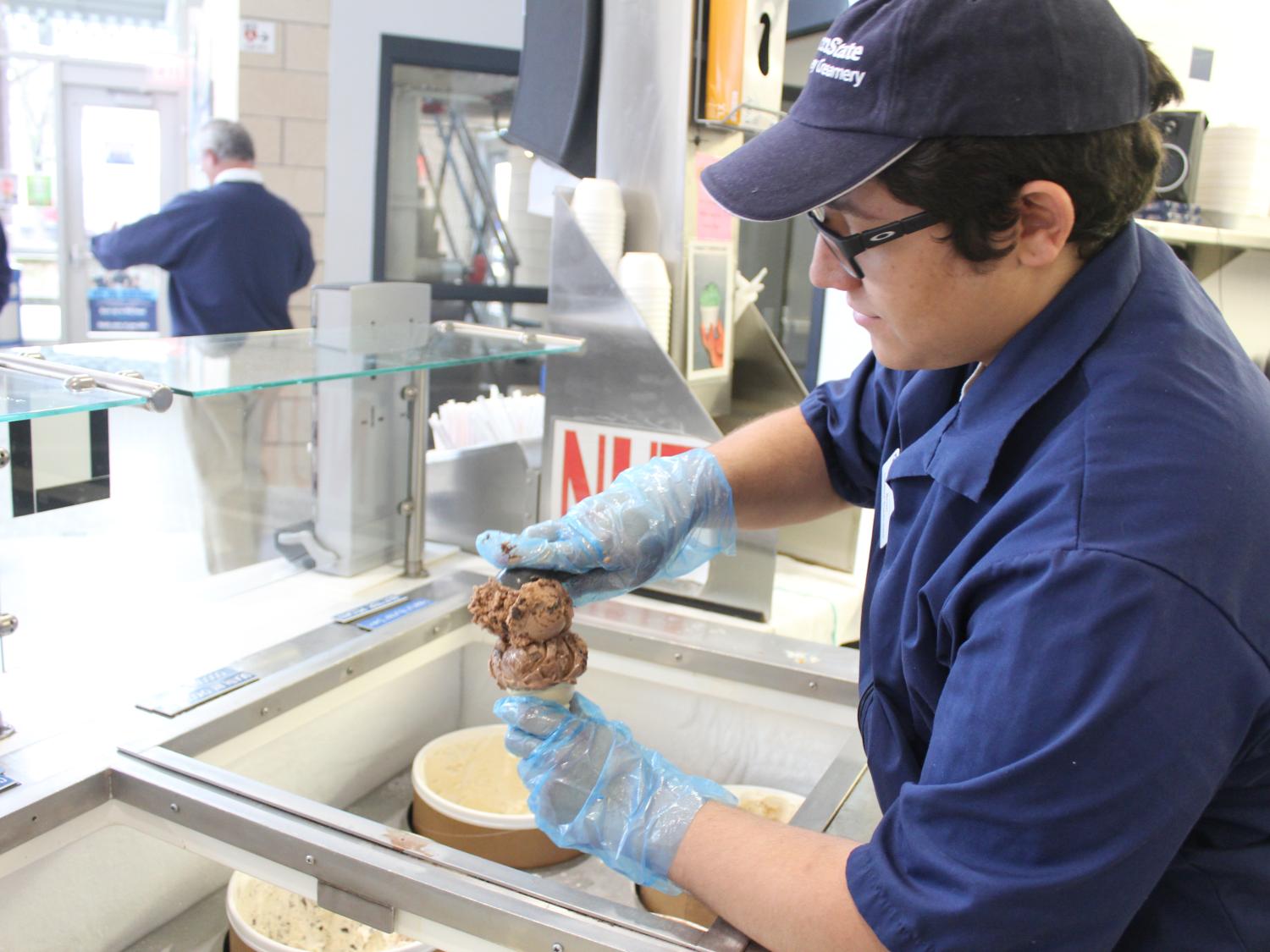A Creamery employee serves up a cone of ice cream.