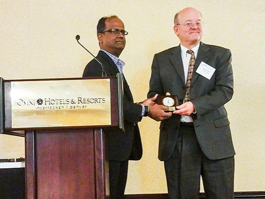 Shree Vikas, the director of Market Intelligence & Business Analysis at ConocoPhillips, awards Andy Kleit the USAEE Senior Fellow Award at the USAEE annual conference in Denver, Colorado.