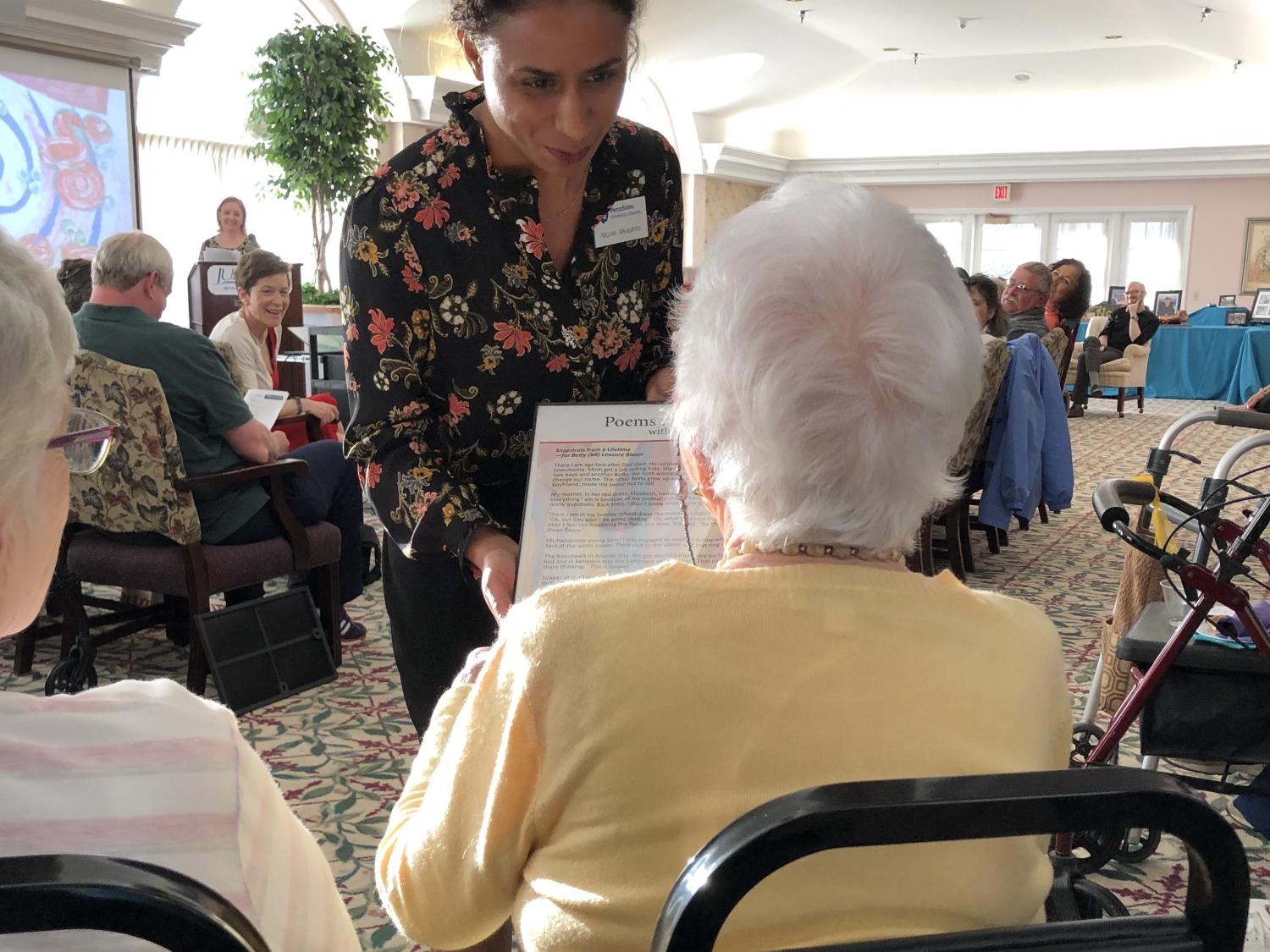 photo of Nicole Myashiro presenting poem to Betty (BB) Leasure Blazer