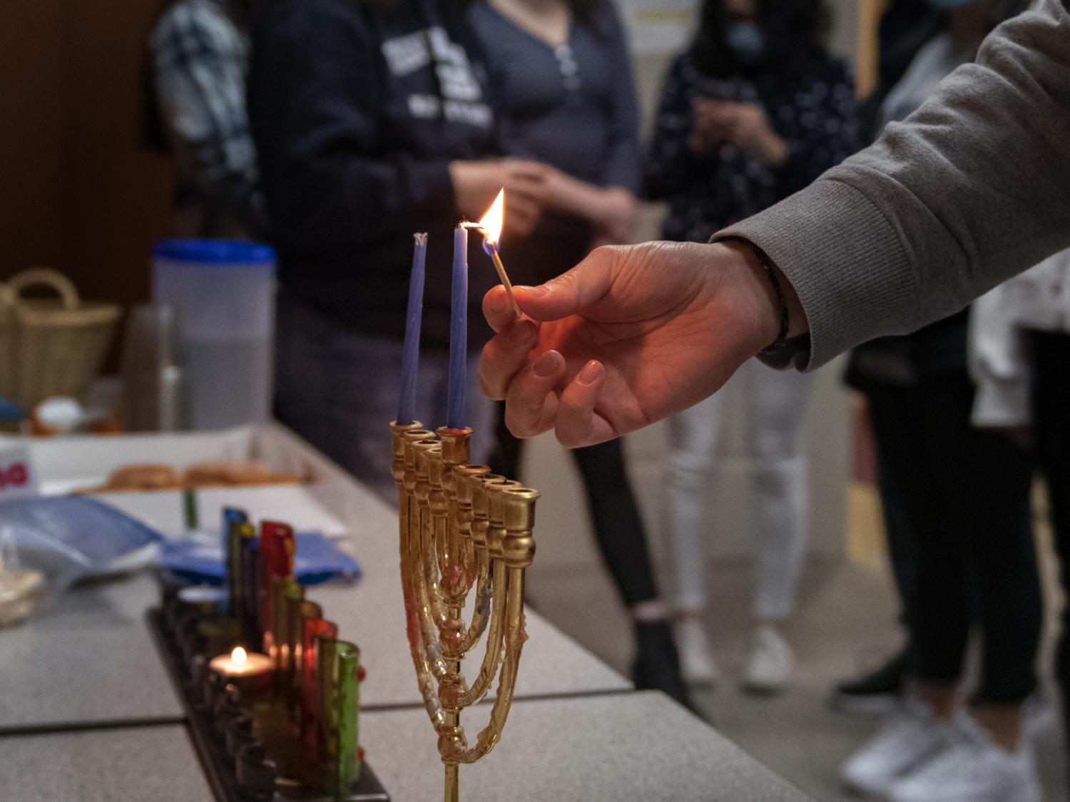 lighting the Menorah first night of Hanukkah