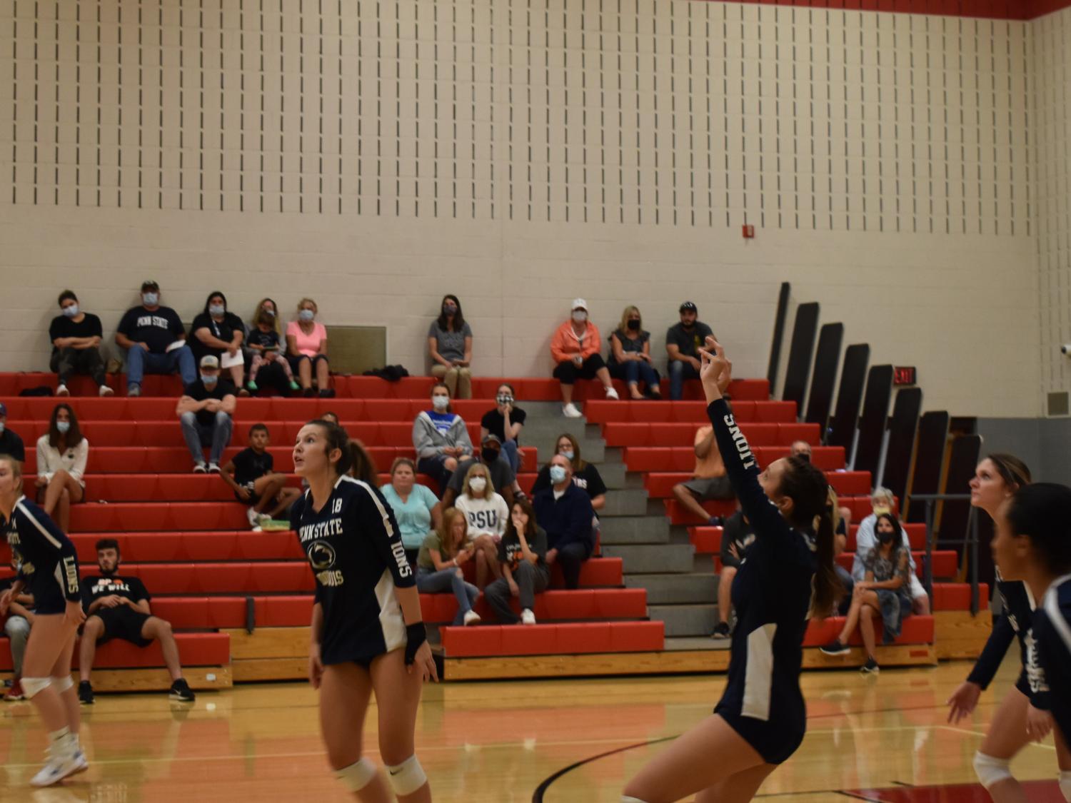 Volleyball players on court during a home match. 