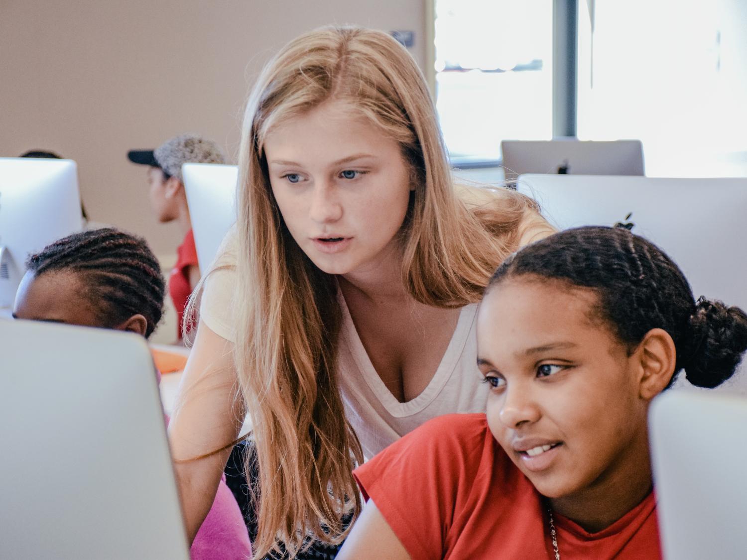 Sydney Gibbard teaches a girl in front of computer screen