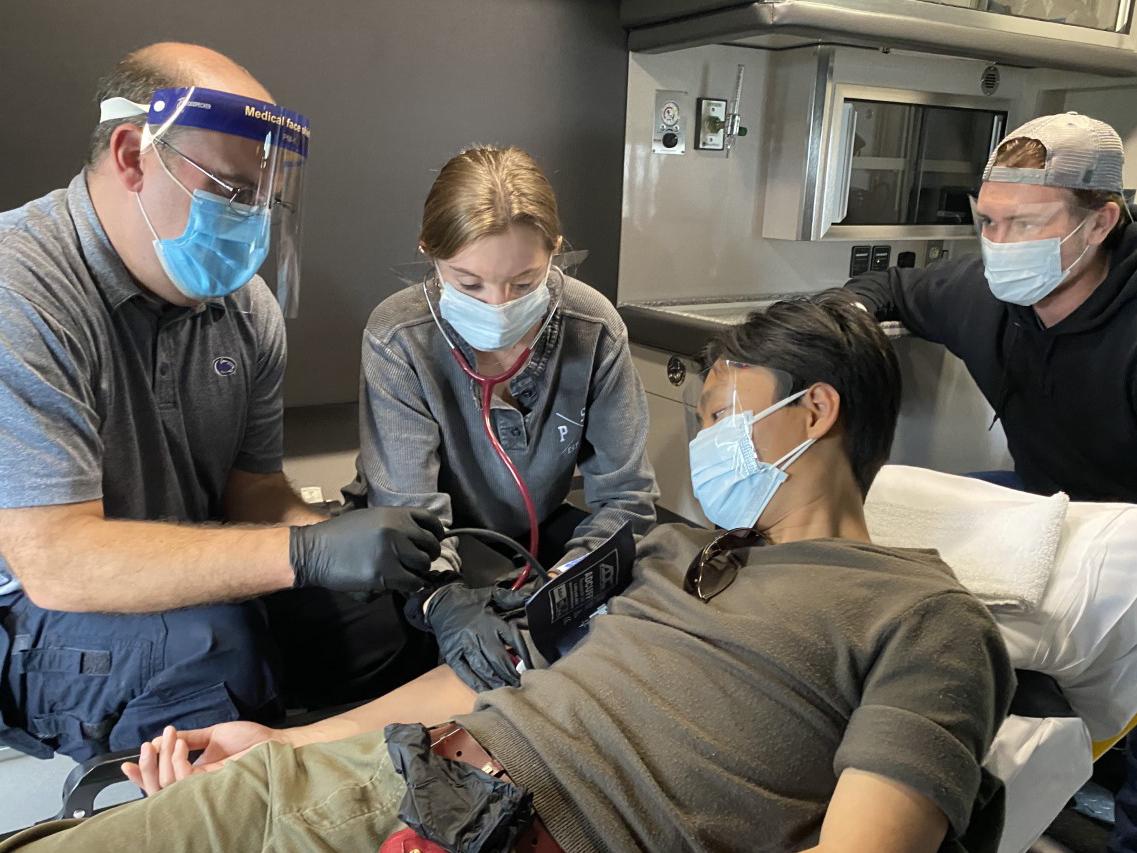 Brent Smith instructs students in Kinesiology 303: Emergency Care to take patient vital signs while in a moving ambulance.