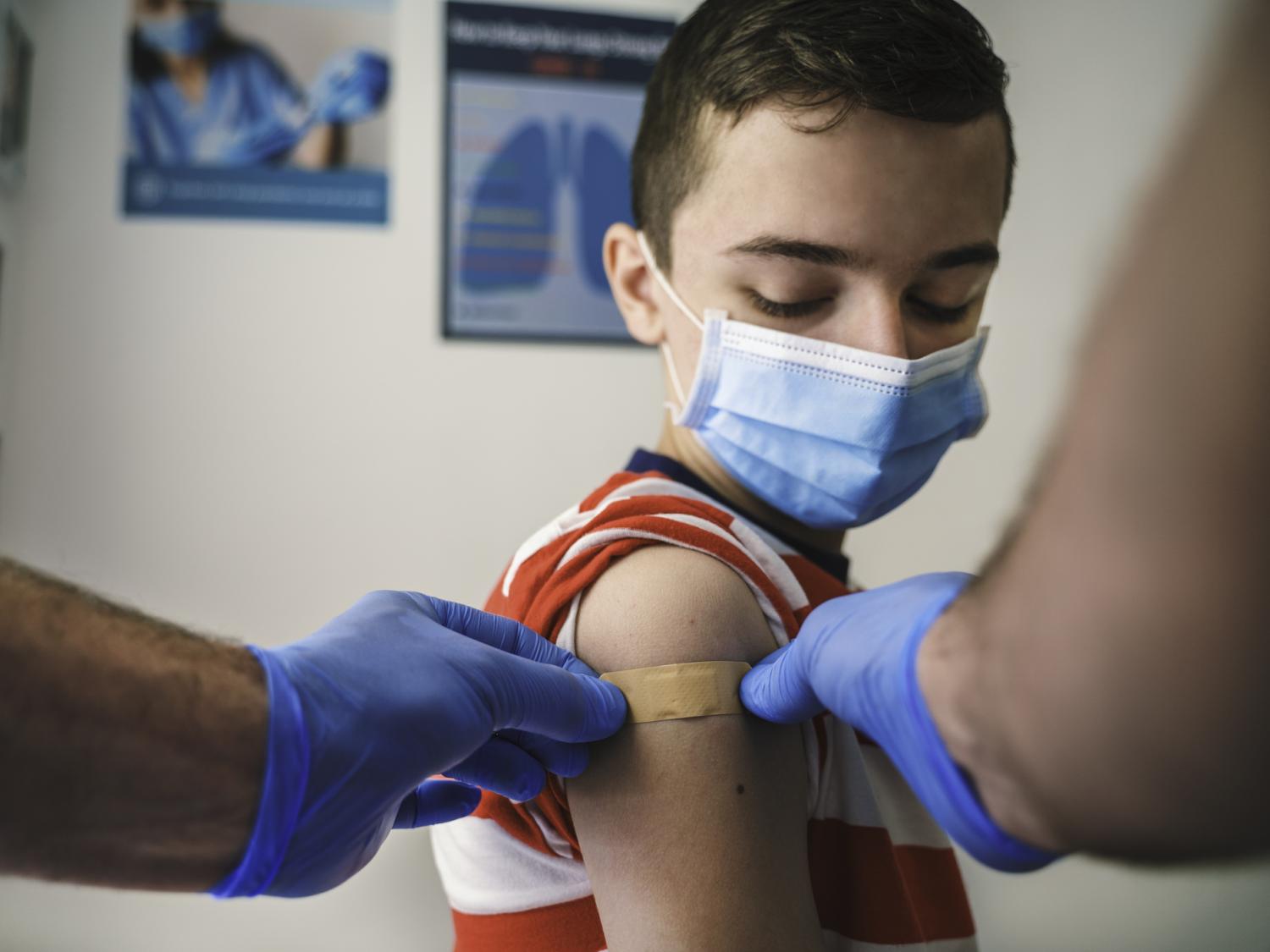 A child receives a bandage after receiving a shot.