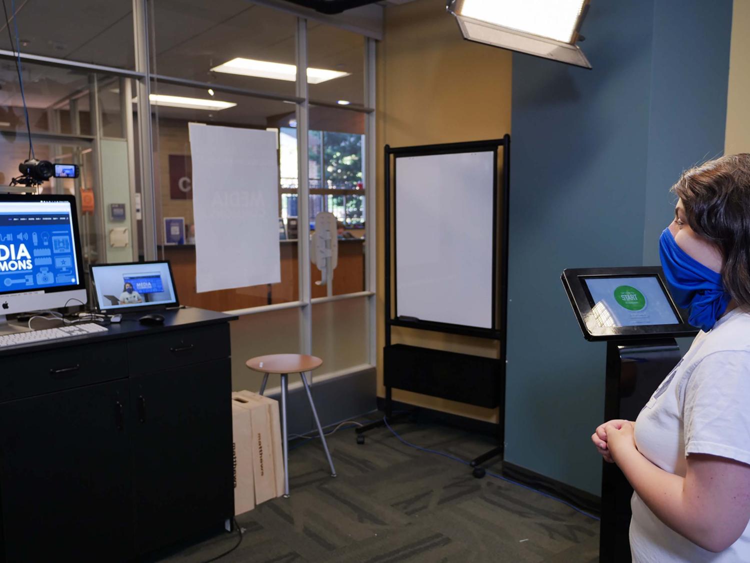 a woman wearing a mask recording a video using one button studio