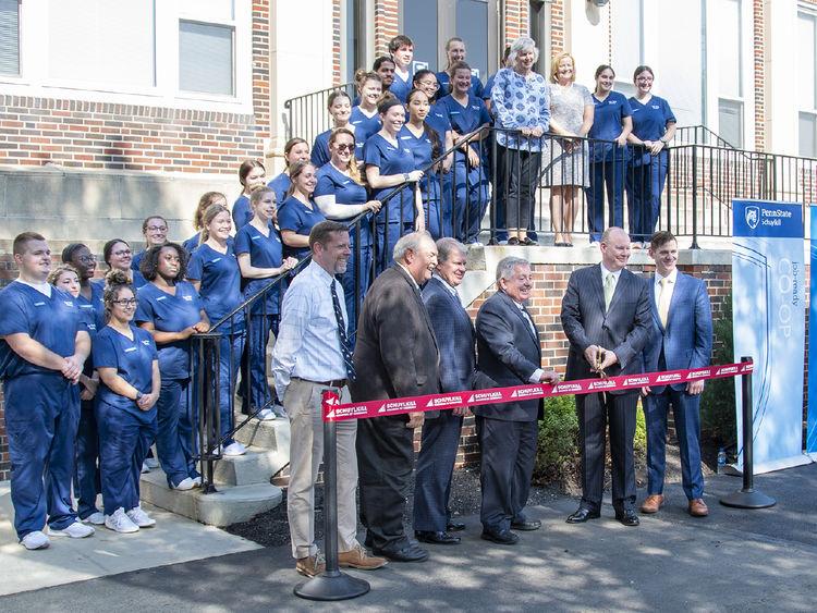 A crowd of people attend a ribbon-cutting for the opening of a new facility