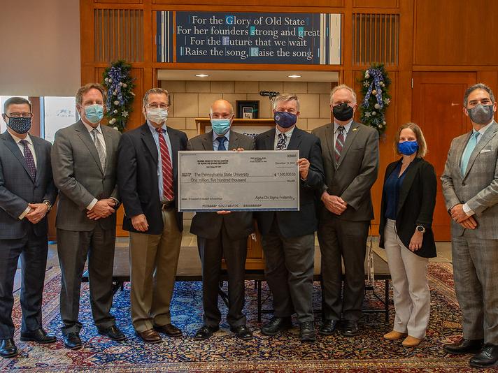 A group of people pose for a photograph with a ceremonial check
