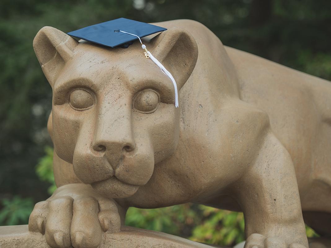 photograph of Nittany Lion Shrine with a graduation cap on the lion's head