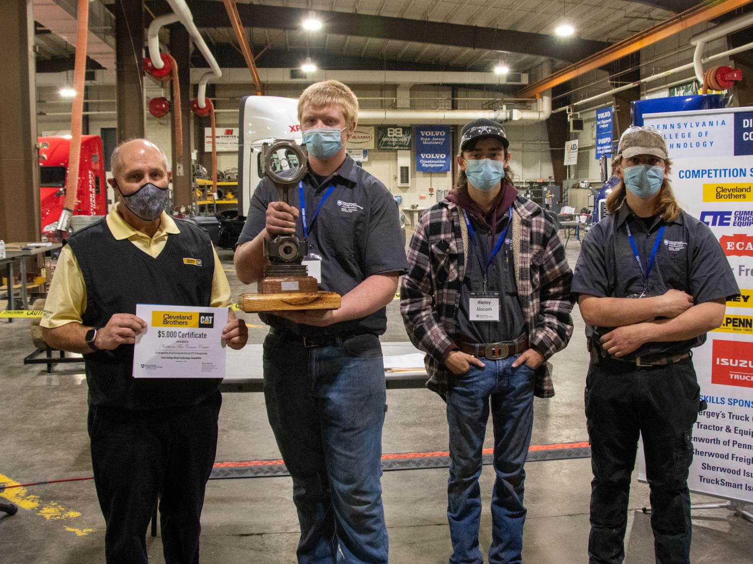 Competitors from Northern Tier Career Center accept a trophy and certificate from Cleveland Brothers Equipment Co. Inc. representative Doug Wetzel.
