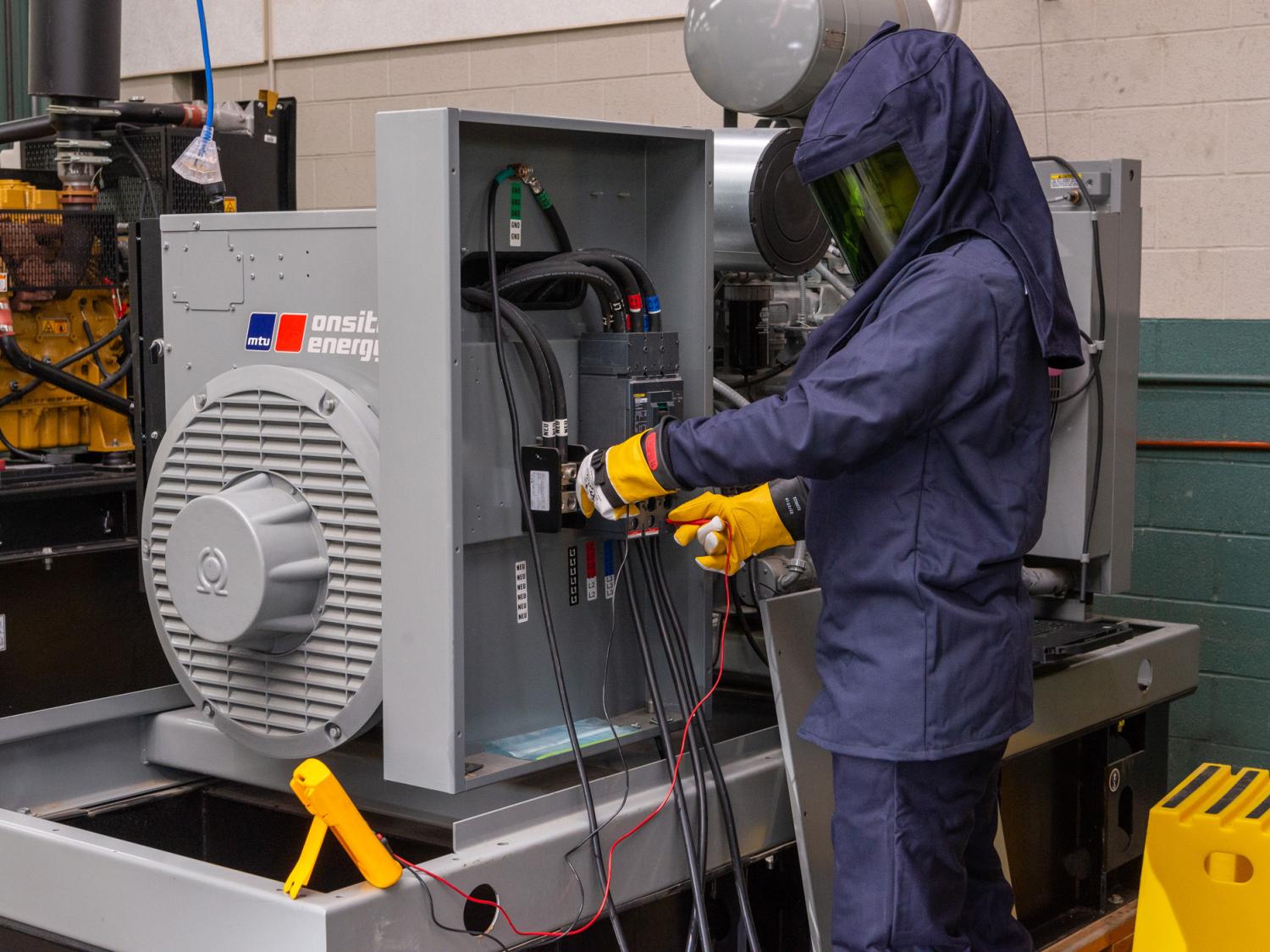 A student wearing arc flash protection gear works in a lab in Penn College’s Schneebeli Earth Science Center.
