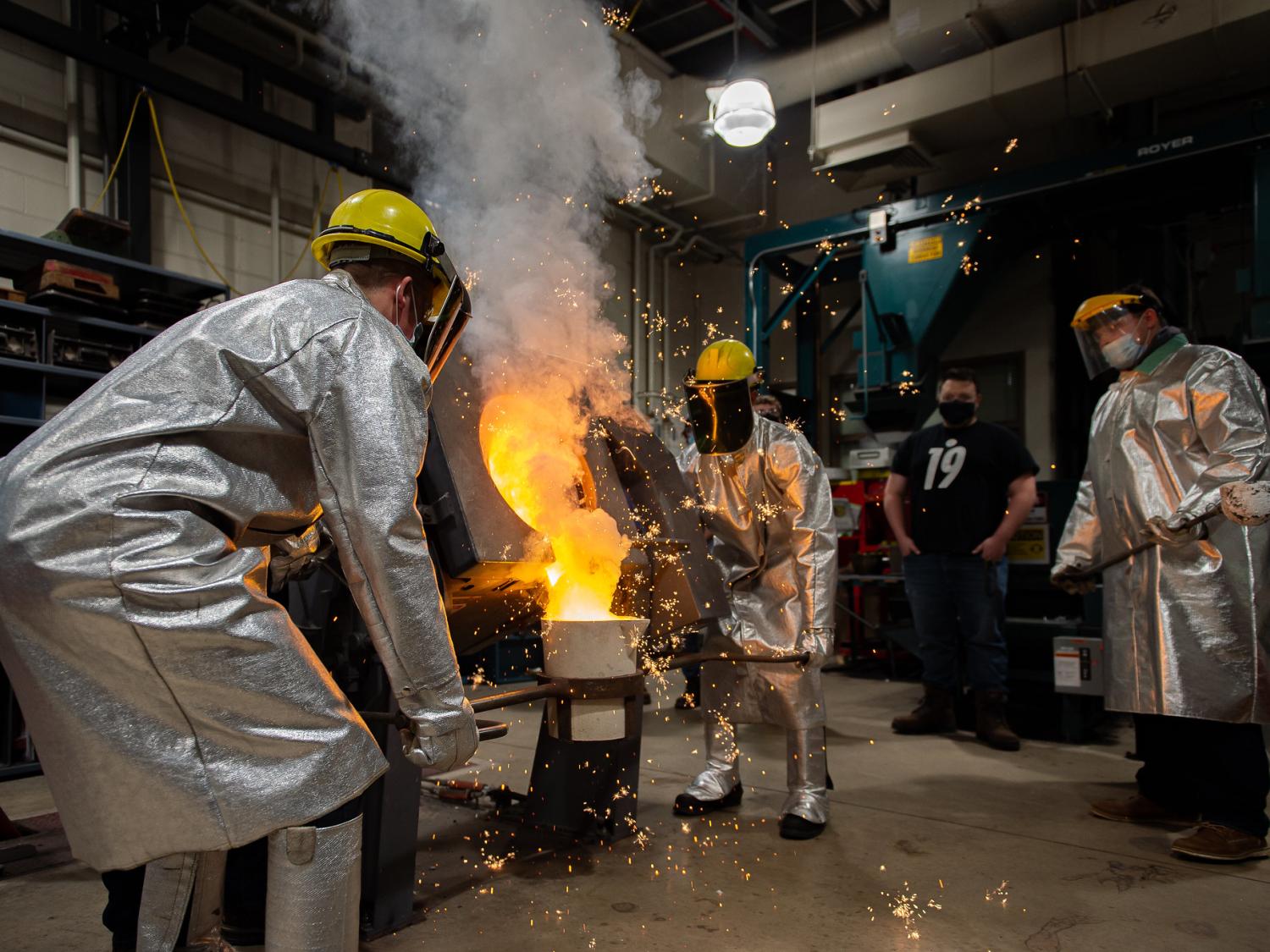 students pour molten cast iron in the Factory for Advanced Manufacturing Education (FAME) lab