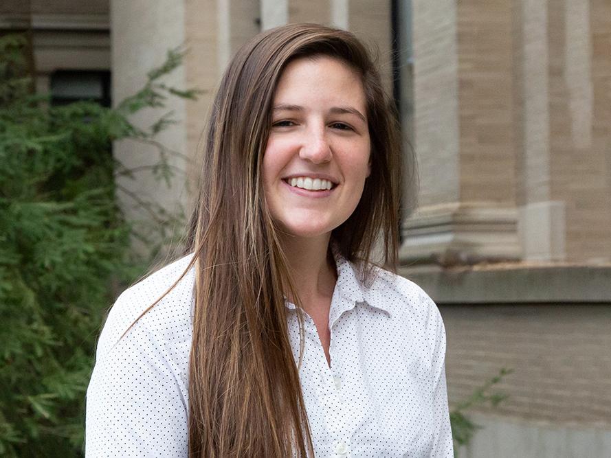Rose Fisher stands in front of academic building