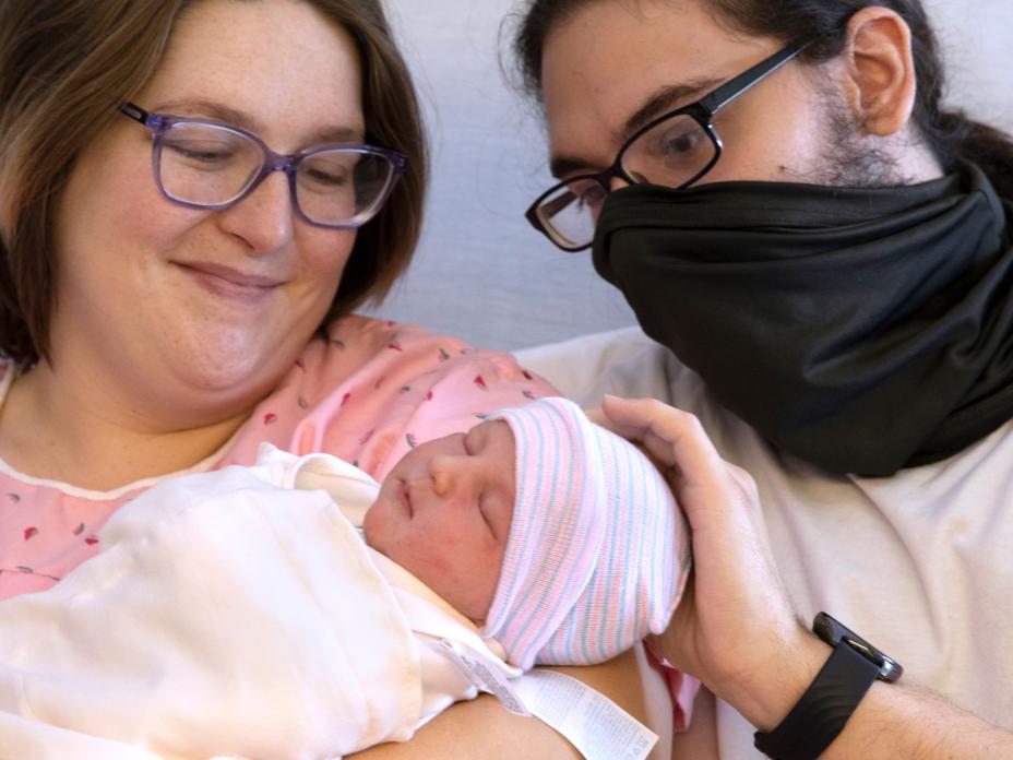 Two parents hold a newborn