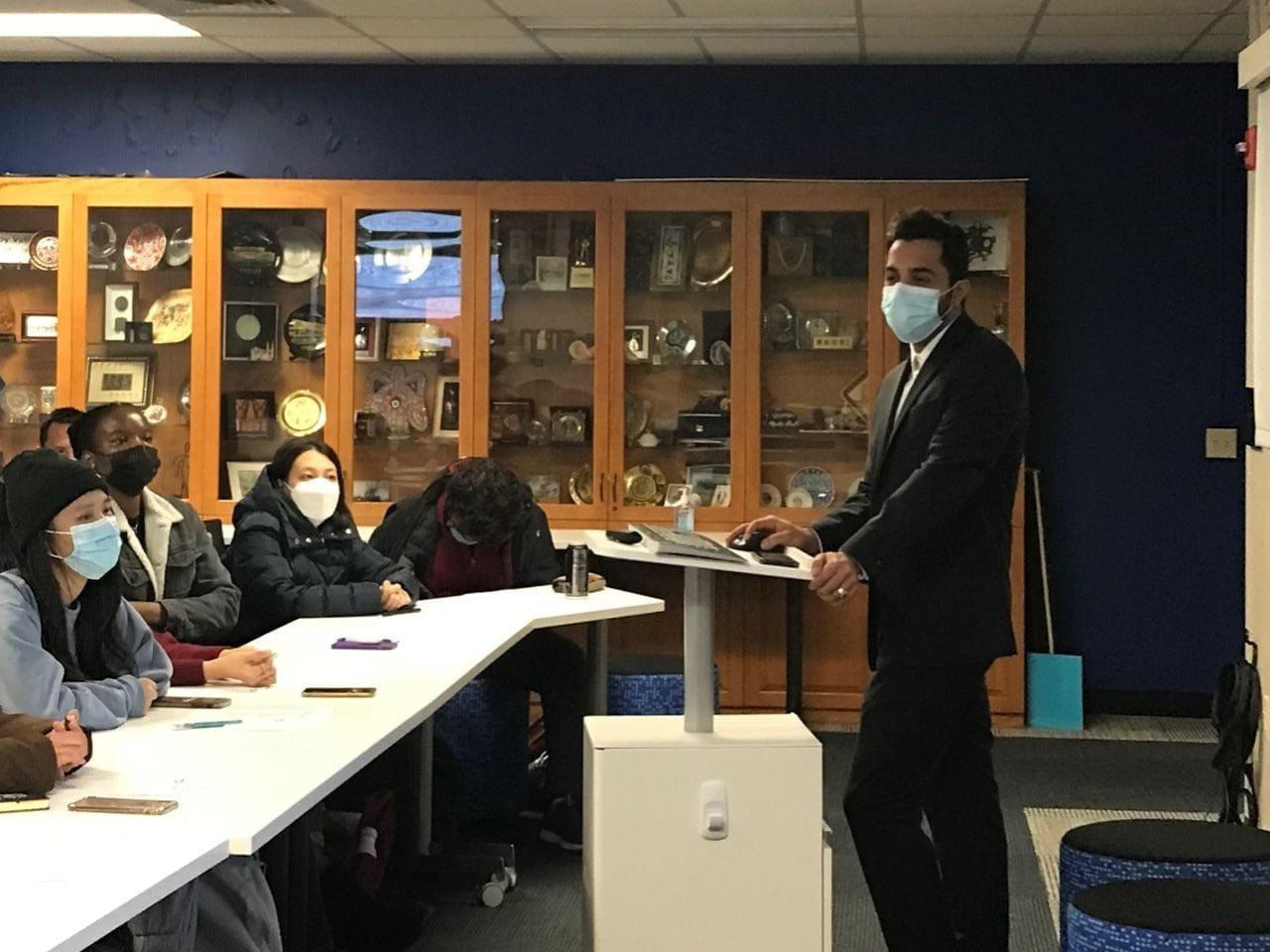 Students meeting in a room with a speaker at the podium