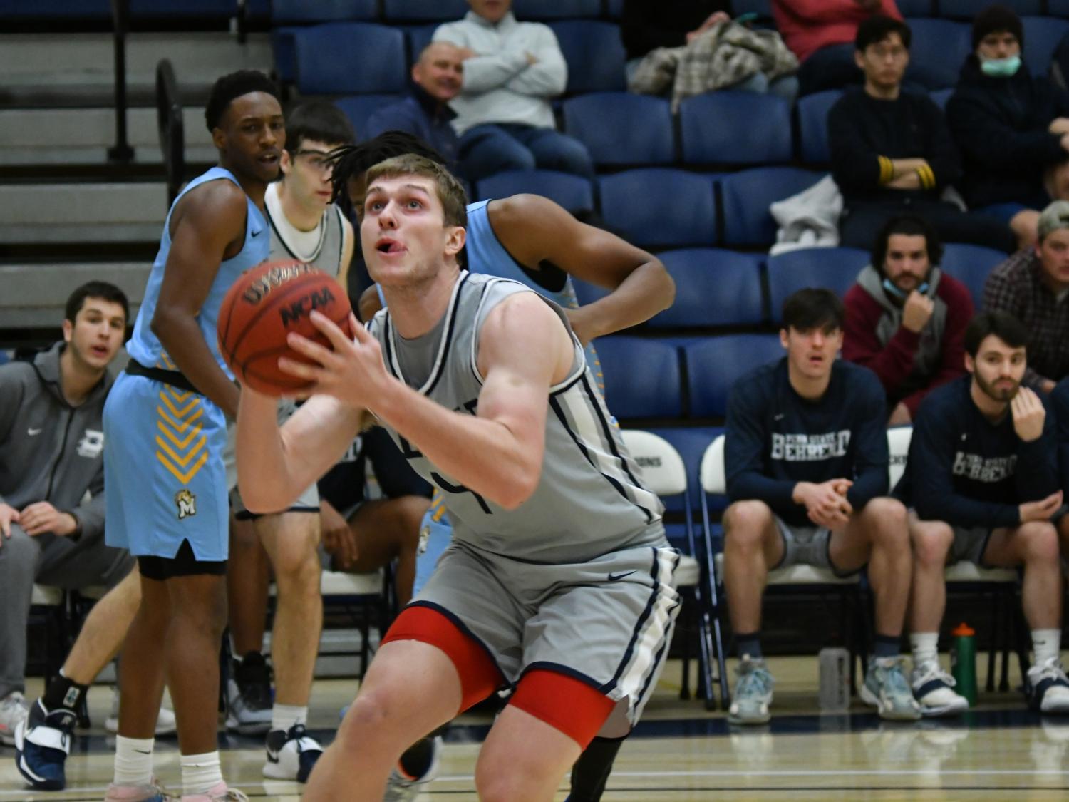 A Penn State Behrend basketball player prepares to shoot the ball.